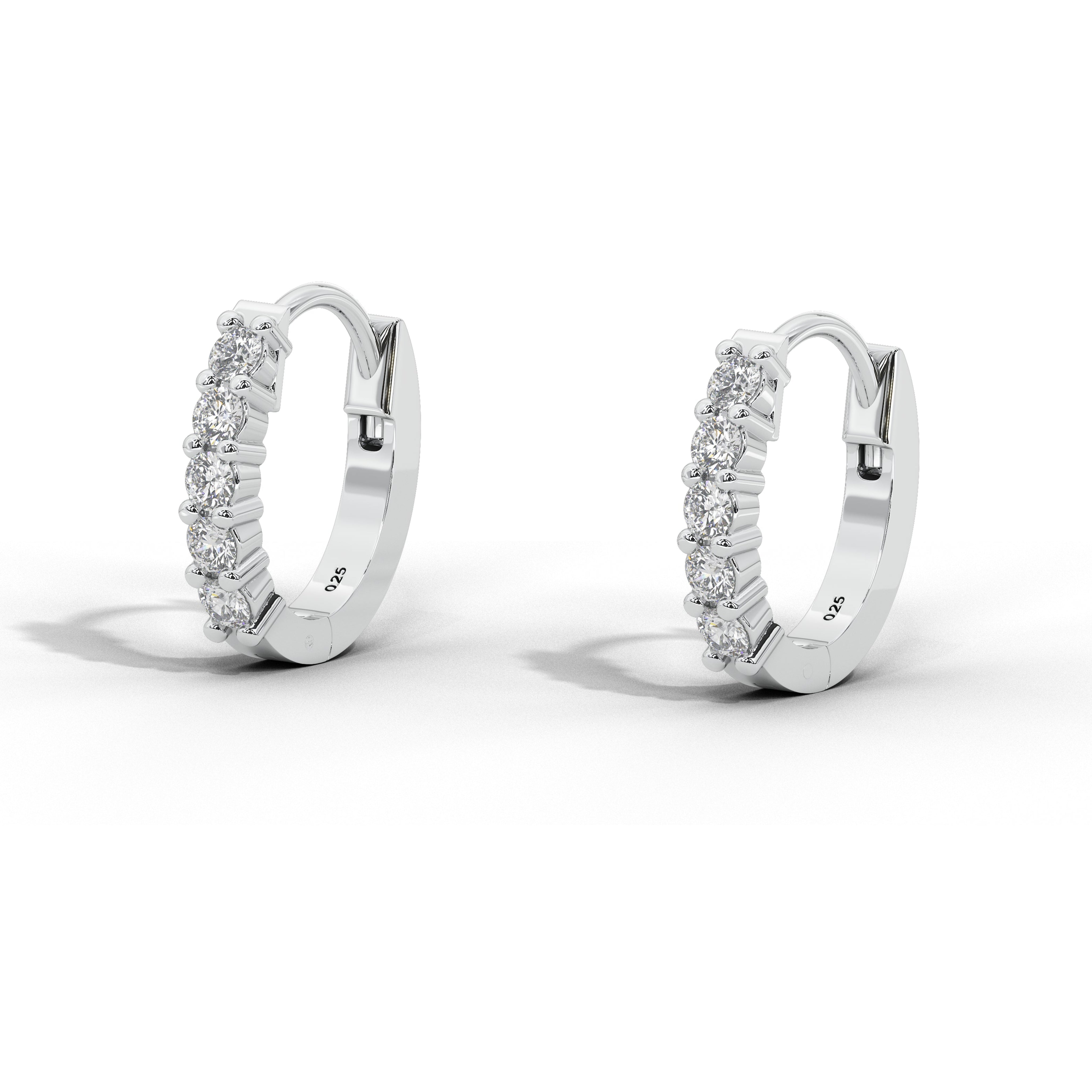 A pair of small white gold huggie hoop earrings with rows of clear stones, shown on a clean white background with soft shadows.