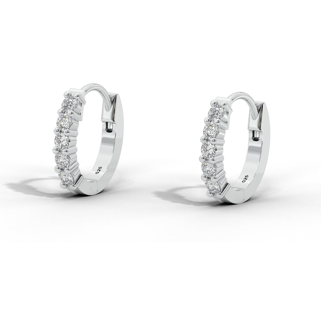 A pair of small white gold huggie hoop earrings with rows of clear stones, shown on a clean white background with soft shadows.