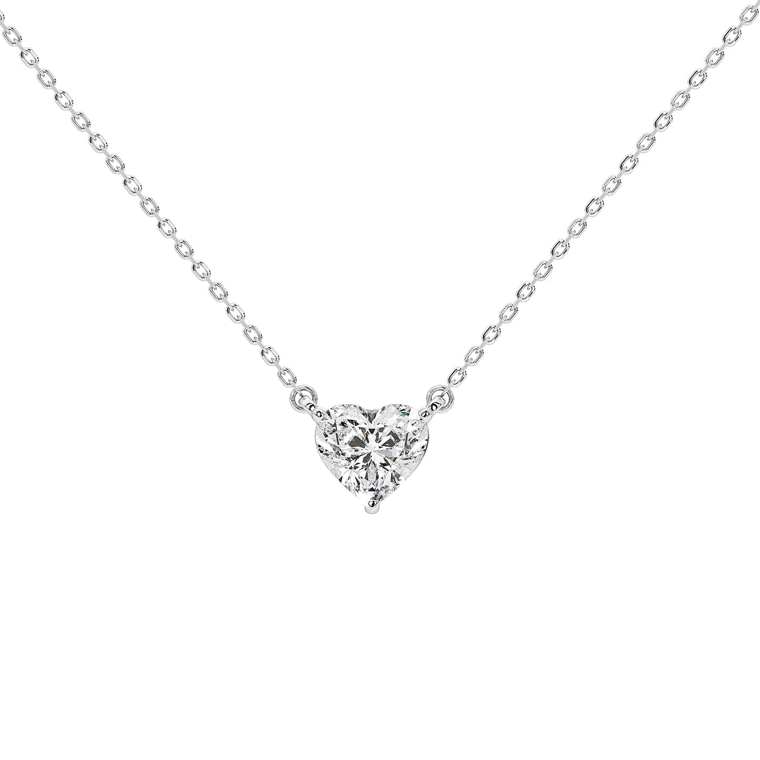 A delicate silver chain necklace with a small heart-shaped cluster of clear diamond in a prong setting, shown against a plain white background.