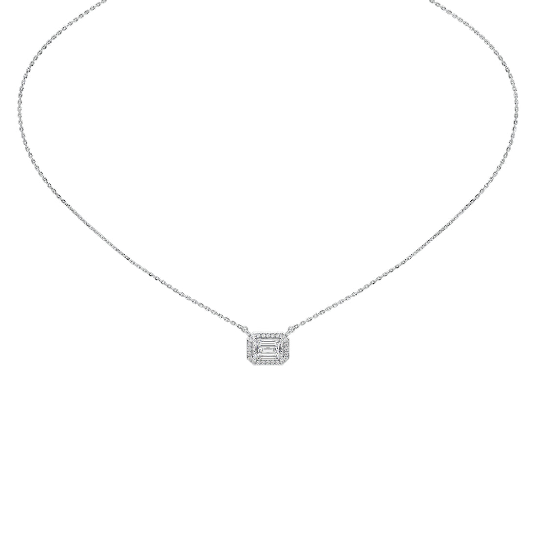 A silver-toned diamond necklace featuring a rectangular emerald-cut pendant surrounded by smaller round diamonds, suspended from a delicate cable chain on a solid white background.